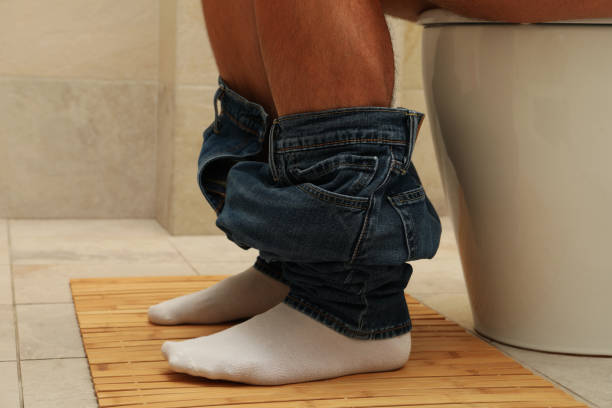 istock A man sits with his pants down on the toilet 1279273834