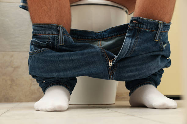 istock A man sits with his pants down on the toilet 1279274666
