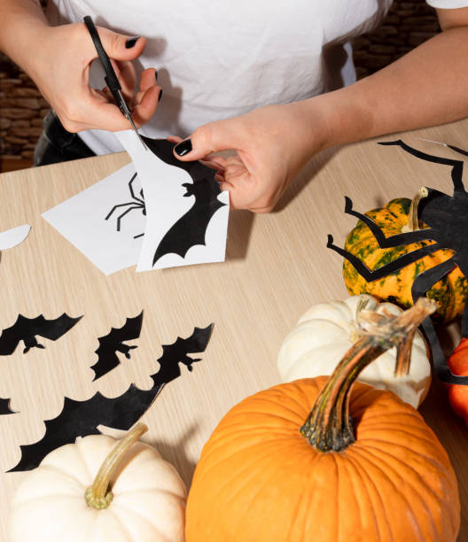 istock Decorations for the Halloween party. A man cuts out bats. 1279274853