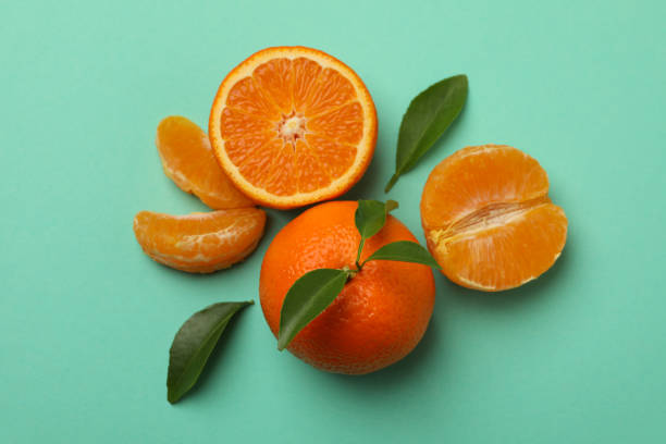 istock Ripe mandarins with leaves on mint background, top view 1279275158