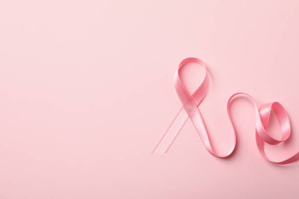 istock Pink awareness ribbon on pink background, space for text 1279275971