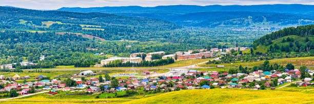 istock Panoramic view from hill to plain with small town in summer cloudy day. Picturesque urban landscape with many colorful houses. Sim, Chelyabinsk region, Russia. Travel blog concept 1279276113