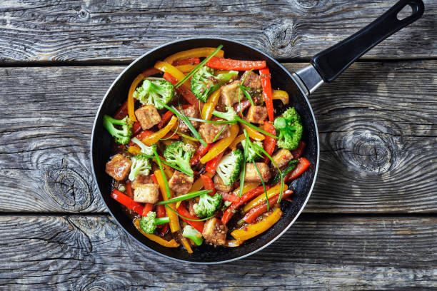 kung pao tofu con peperoni misti, broccoli e scalogno - padella foto e immagini stock