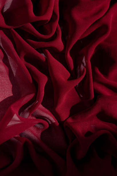istock Smooth elegant burgundy chiffon fabric abstract background. Dark red wine silk luxury cloth texture light surface design 1279276987
