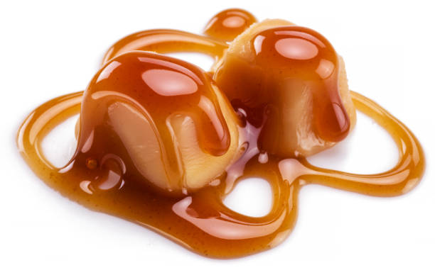 istock Caramel candies covered with melted sugar caramel isolated on white background. 1279278486