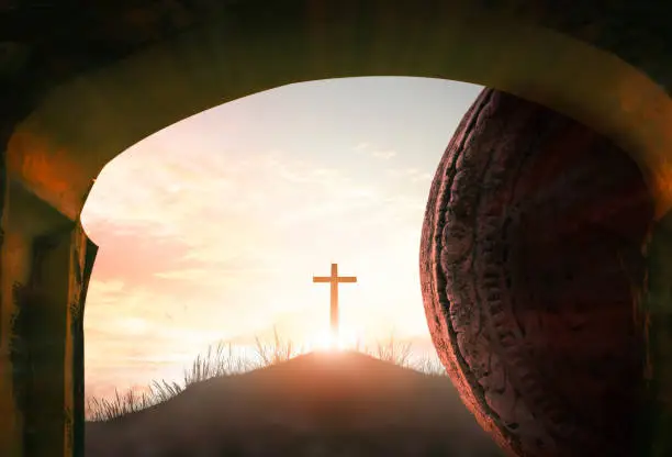 Easter  concept: Tomb empty with cross on sunset background