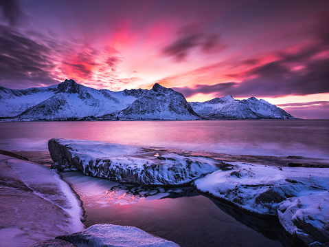 Long exposure of dramatic landscape of Steinfjord during beautiful blue hour sunset in Senja, Norway.