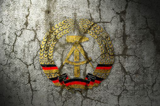 national symbol of German Democratic Republic (GDR) on a cracked wall