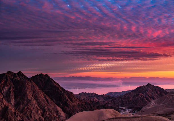 View on mountains and desert with dead sea and Eilat in the background at sunset in Israel.