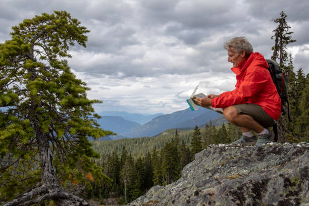 istock Hiker looks to map for directions on elevated mountain ridge 1279283035