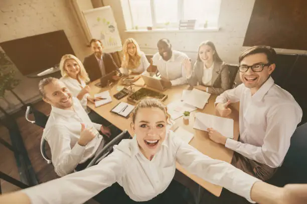 Photo of positive smart investors have gathering start-up growth plan training, make selfie enjoy way-out crisis discussion in workplace workstation boardroom