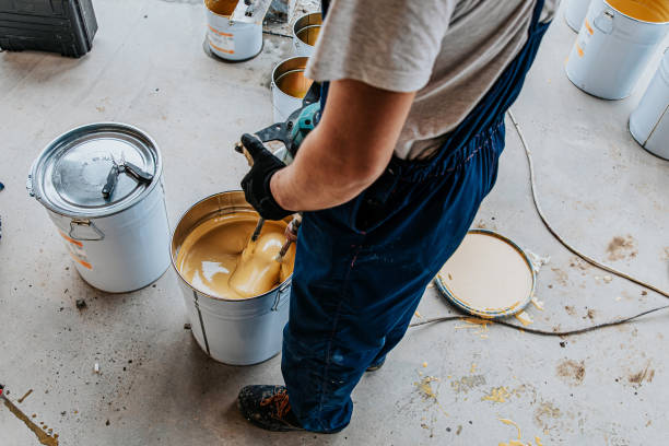 istock Worker mixing yellow epoxy resin with the mixer in a tin bucket 1279290128