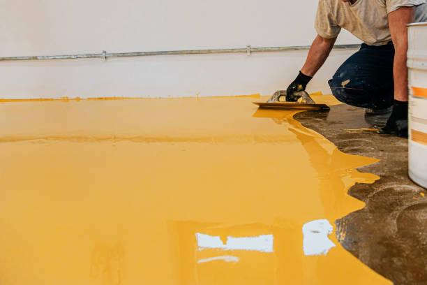 istock Worker, coating floor with self-leveling epoxy resin in industrial workshop. 1279290143