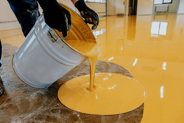 a construction worker apply epoxy resin in an industrial hall - levelling instrument imagens e fotografias de stock