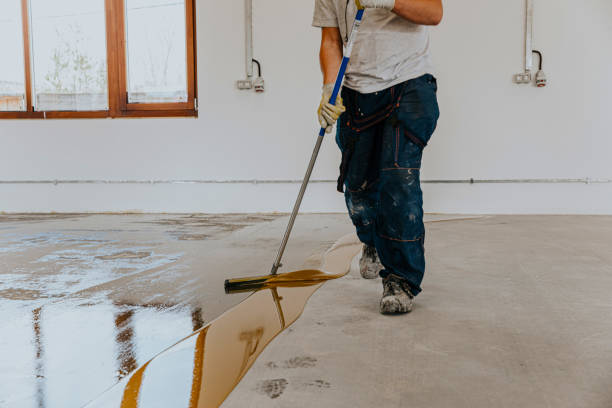 istock A worker applies the primer to the concrete floor.Epoxy resin project 1279290285