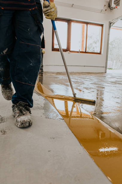 istock A worker applies the primer to the concrete floor.Epoxy resin project 1279290347