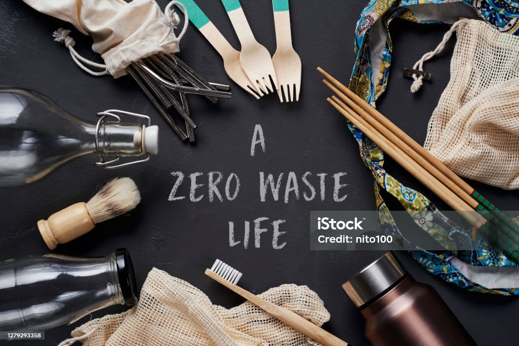no-plastic items and text a zero waste life a pile of no-plastic sustainable household items, such as refillable metal and glass bottles, shopping mesh bags, or reusable wooden toiletries, cutlery and chopsticks, and the text a zero waste life Alternative Lifestyle Stock Photo