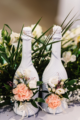 Glass of champagne in front of wedding bouquet of flowers