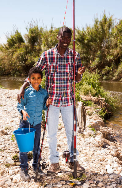 istock Man and boy with bucket of catch 1279296152