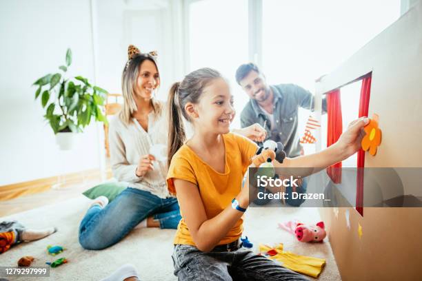 Family At Home Playing With Daughter Having Theater Performance With Finger Puppets Stock Photo - Download Image Now