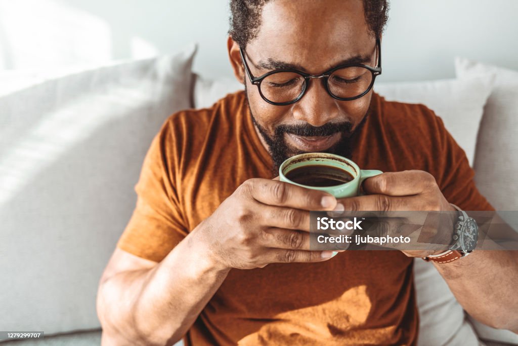 Enjoying the peace of a Saturday morning Cropped shot of a handsome young man relaxing with a cup of coffee Coffee - Drink Stock Photo