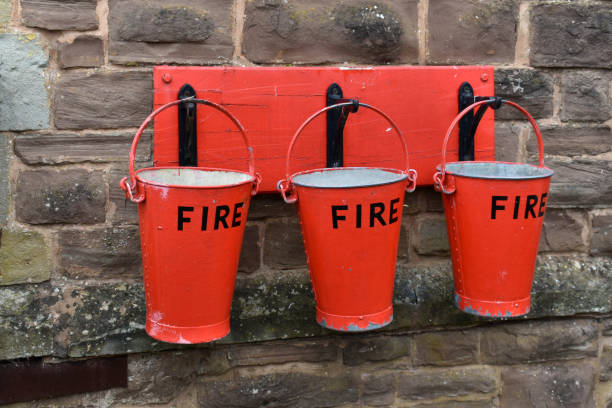 외부 돌 벽에 나무 플라크에 후크에 매달려 3 빨간 화재 양동이의 닫기 - fire bucket 뉴스 사진 이미지
