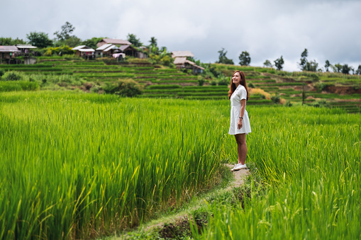 A beautiful young asian woman walking in terrace paddy field