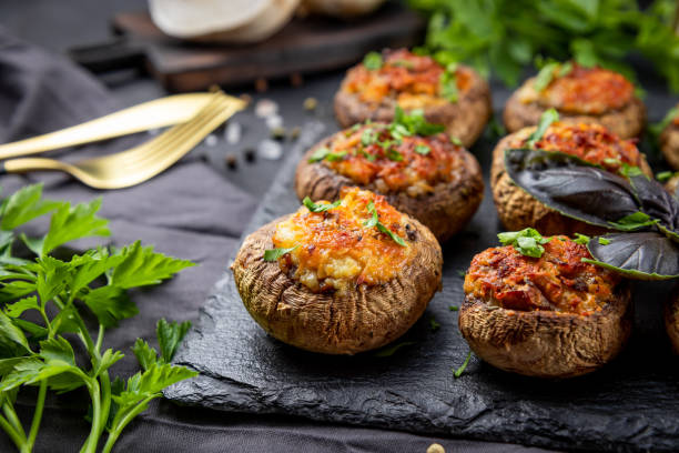 istock Baked stuffed mushrooms on a black slate plate close up 1279305221