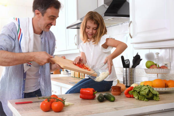 istock Happy father and daughter preparing vegetables in the kitchen 1279306892