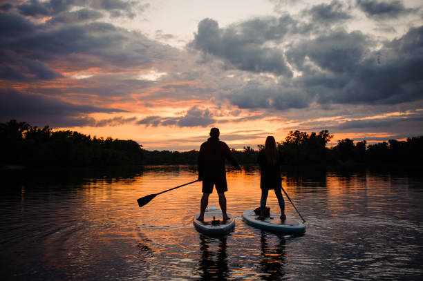 istock romantic view on man and woman on sup boards floating on river 1279307530