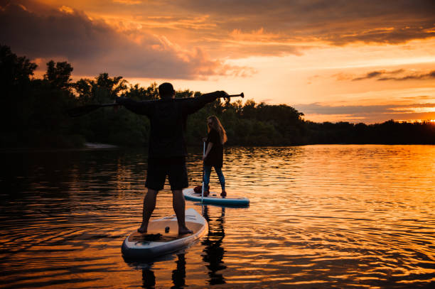 istock man and woman float along the river standing on sup boards with oars 1279307730