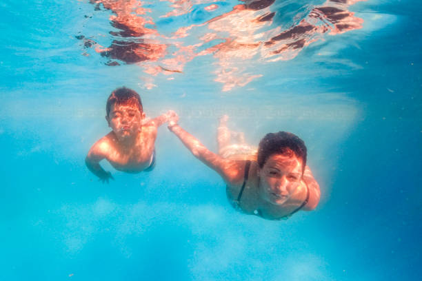 istock Mother and son diving on a swimming pool 1279308443