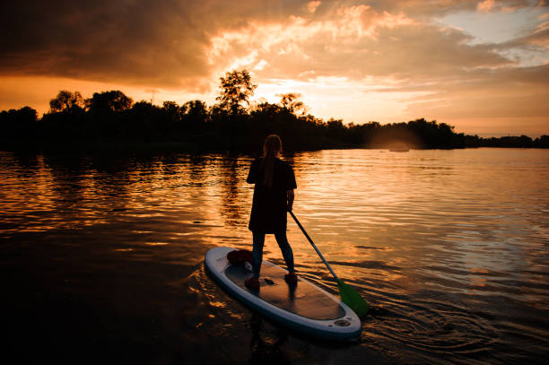 istock rear view of young woman on sup board floating on river 1279308629