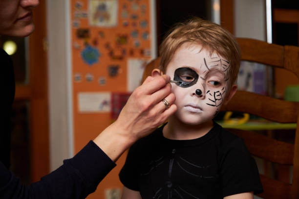 istock Mother is helping son with Halloween makeup 1279312133