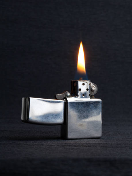 istock Close-up of metal gas lighter with burning fire on grey background 1279314654