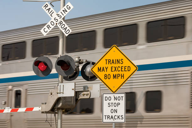 high speed train warning sign at railroad crossing with motion blur of train in background. concept of railroad crossing safety, danger and transportation industry - railroad sign imagens e fotografias de stock