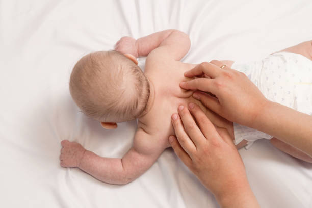 istock baby massage, close-up hands on baby back 1279315592