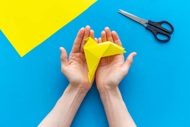 istock DIY concept. Doing origami paper bird, Top view 1279316556