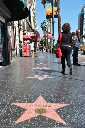 People visit Walk of Fame in Hollywood. Hollywood Walk of Fame features more than 2,500 stars with inscribed celebrity names.