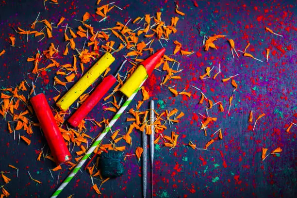 Photo of Diwali Diya with Fire Crackers over Rangoli background