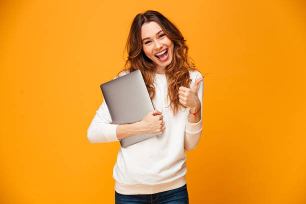 istock Happy brunette woman in sweater holding laptop computer 1279321714