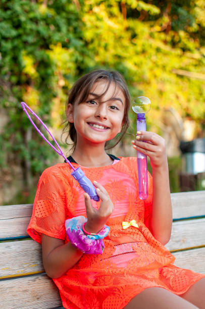 istock Cute girl playing with soap bubbles 1279322322