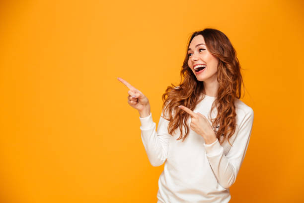 istock Beautiful cute young woman pointing. Looking aside. 1279322340