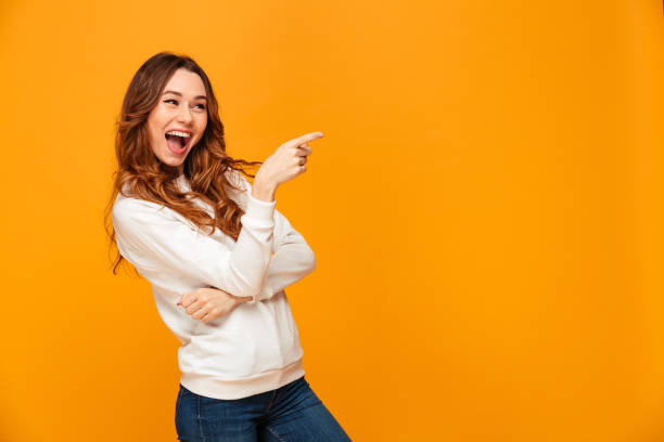 istock Cheerful brunette woman in sweater pointing away 1279323150