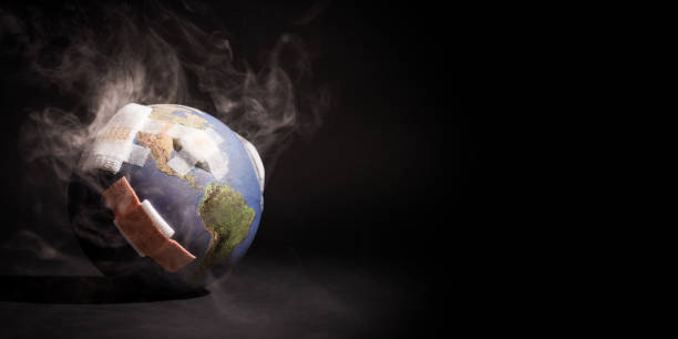 Global warming impact concept - Earth (globe) with bandages covered with smoke on black background.