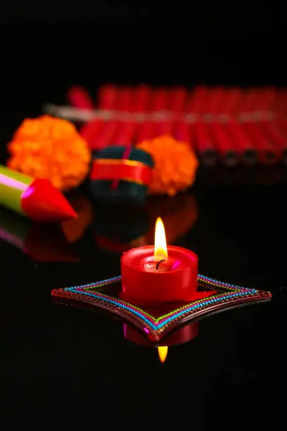 Photo of Indian festival Diwali, candle with crackers over dark background