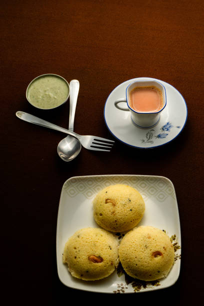 Delicious home made Rava idli with chutney and a cup of Tea on the table