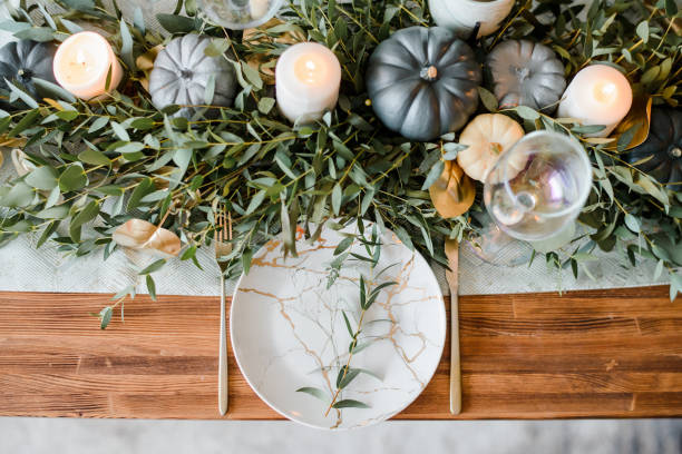istock Halloween Table setting on dark background. Dish with sweets s on a dark table with black and gold pumpkin. Flat lay, top view trendy holiday concept. 1279332750