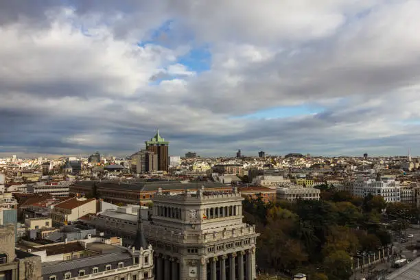 Photo of Various vintage buildings in urban Madrid Spain receding into background with cloudy sky