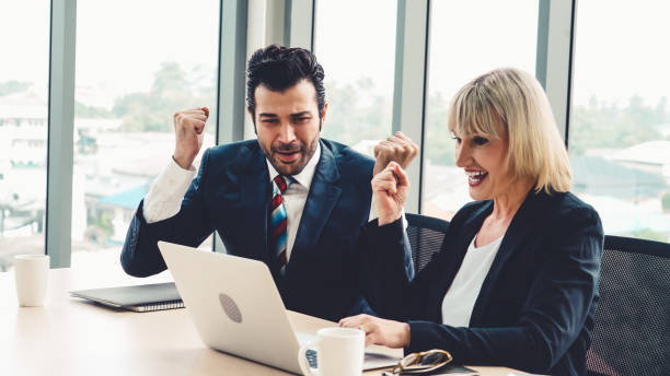 istock Two happy business people celebrate at office 1279334768